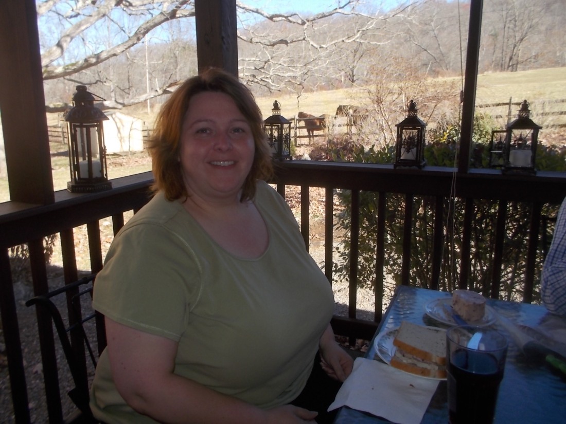 112916 Lise at breakfast on the porch, horses behind.JPG
